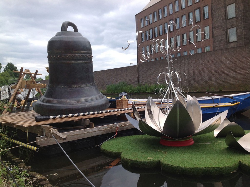 grote bronzen klok en aluminium lotus aan de kade